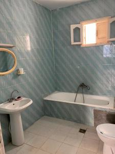 a bathroom with a sink and a tub and a toilet at Dar nawara in Kelibia