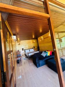 a living room with a blue couch and wooden walls at Ella Wood Cabin in Ella