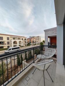 a balcony with two chairs and a view of a street at Lux Studio Lustica Bay and Car in Luštica