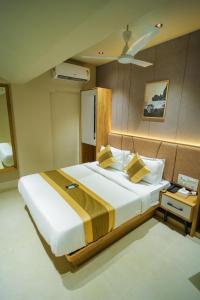 ein Schlafzimmer mit einem großen Bett und einem Deckenventilator in der Unterkunft HOTEL AMBER PARAMOUNT in Mumbai