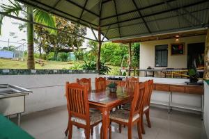 a dining room with a wooden table and chairs at Cabinas Los Colibris in Pocosol
