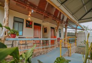 a house with a balcony with a table and chairs at Cabinas Los Colibris in Pocosol
