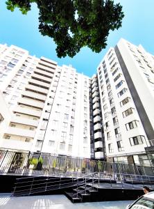a white apartment building with a fence in front at Ap Blessedplace Rîșcani-New Bldg in Chişinău