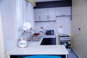 a kitchen with white cabinets and a white counter top at The VIP Afriqhomes in Nairobi
