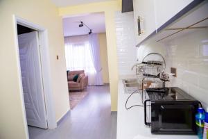 a kitchen and living room with a sink and a stove at The VIP Afriqhomes in Nairobi