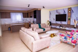 a living room with two couches and a kitchen at The VIP Afriqhomes in Nairobi