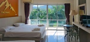 a bedroom with a bed and a large window at The Pano Hotel And Residence in Ao Nang Beach +44 photos