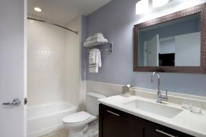 a bathroom with a sink and a toilet and a mirror at Meliá Orlando Celebration in Orlando