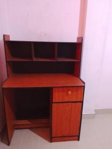 a wooden desk in a corner of a room at TRAVAL dksr in Anuradhapura