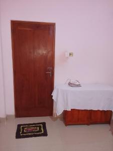 a room with a bed and a wooden door at TRAVAL dksr in Anuradhapura