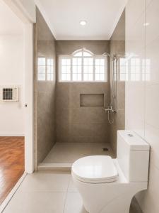 a white bathroom with a toilet and a shower at Trip Nest Homestay in Manila