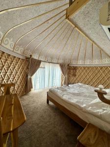 a bedroom with a bed and a large window at Tangnuru eco yurts in Bosteri