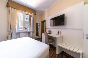 a hotel room with a bed and a desk and a window at Hotel University in Bologna