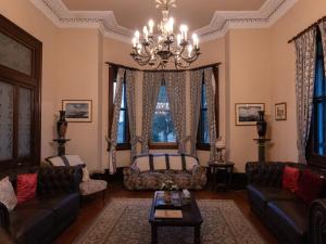 a living room with couches and a chandelier at Lochinvar House in Lochinvar