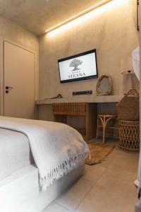 a bedroom with a bed and a tv on the wall at Villa Steana in Makri