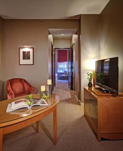 un salon avec une télévision et une table dans l'établissement Hotel Giraffe by Library Hotel Collection, à New York