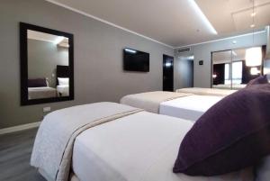 a hotel room with two beds and a mirror at Howard Johnson Plaza by Wyndham Buenos Aires Florida Street in Buenos Aires