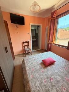 a bedroom with a bed with a red pillow on it at I Barsan in Groppo