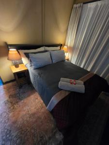 a bedroom with a bed with two towels on it at The Cottage Inn in Modimolle