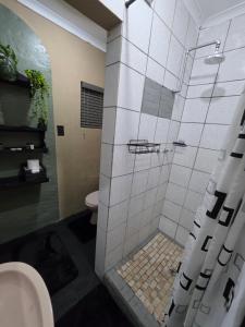 a bathroom with a shower with a sink and a toilet at The Cottage Inn in Modimolle