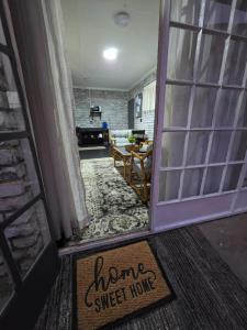 an open door with a sign that says home sweet home at The Cottage Inn in Modimolle
