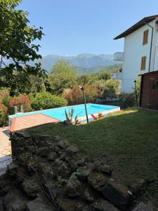 a swimming pool in a yard next to a house at I Barsan in Groppo