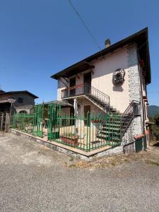 a building with a green fence in front of it at I Barsan in Groppo