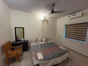 a bedroom with a bed with a mosquito net at Kuppath Inn in Cochin