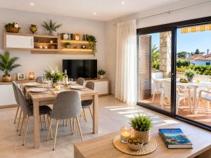 a dining room and living room with a table and chairs at CASA PUIG, Piscina Privada ,Aire Acondicionado Free in L'Escala