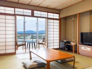 a living room with a table and a television at The Gran Resort Elegante Shirahama in Shirahama