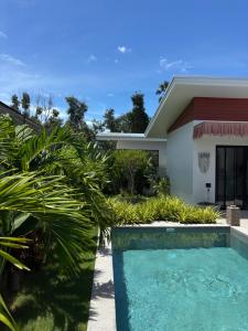 a house with a swimming pool in front of a house at Villa jay in Na Mueang