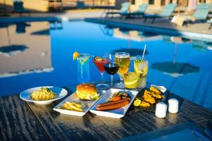 a table with food and drinks next to a pool at Arabian Nights Resort & Spa in Shāhiq +37 photos