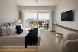a bedroom with a bed and a balcony with a view at Paradisia Suites in Naxos Chora
