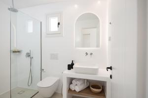 a white bathroom with a sink and a shower at Paradisia Suites in Naxos Chora