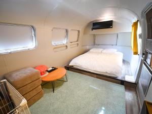 a small bedroom with a bed and a table at FOG villa&spa in Kirishima