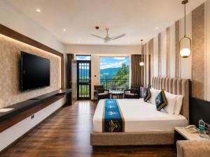 a hotel room with a bed and a flat screen tv at Kavin - The Chail Resort in Chail