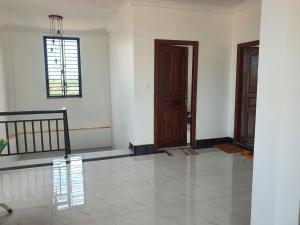 an empty room with two doors and a tile floor at The Y Shop in Phumĭ Bŏs Tarĕt