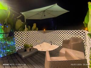 a table and an umbrella on a deck at Tucan container in Fortuna