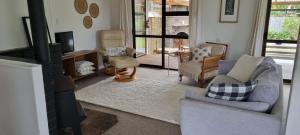 a living room with a couch and chairs and a tv at Point Wells Village Bach in Omaha
