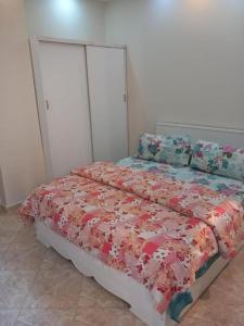 ein Schlafzimmer mit einem Bett, einer Steppdecke und Kissen in der Unterkunft Xtoy in Zeerust