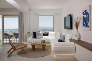 a living room with a white couch and a table at Paradisia Suites in Naxos Chora