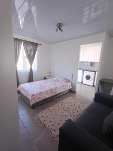 ein weißes Schlafzimmer mit einem Bett und einem Fenster in der Unterkunft Xtoy in Zeerust