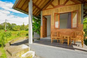 a cabin with a table and chairs on a porch at Bee Camp Bedugul by AGATA in Bedugul