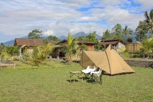 a tent and a chair in front of a house at Bee Camp Bedugul by AGATA in Bedugul