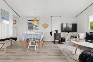 a living room with a table and a fireplace at Nordic Style Summer House For Two in Bogense +9 photos