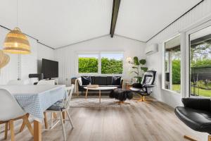a living room with a table and chairs at Nordic Style Summer House For Two in Bogense