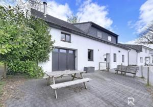 a white house with a picnic table in front of it at Zur alten schule in Amblève