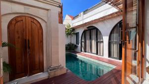 a house with a swimming pool and a wooden door at Arrum Villa in Ungasan +13 photos