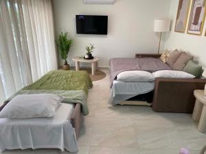 a living room with two beds and a couch at Nikol's central suite 2 in Nea Peramos