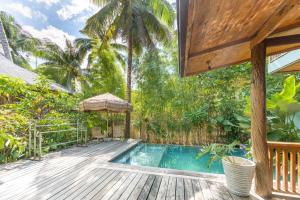 a swimming pool with a wooden deck and a house at Camanolo Residence in General Luna